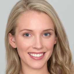 Joyful white young-adult female with long  brown hair and blue eyes