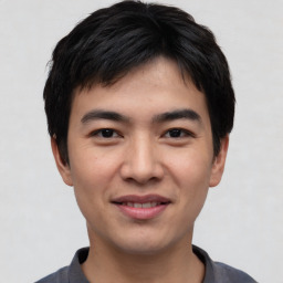 Joyful asian young-adult male with short  black hair and brown eyes