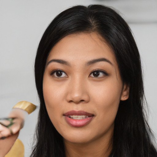 Joyful asian young-adult female with long  black hair and brown eyes