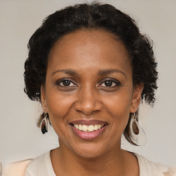 Joyful black adult female with medium  brown hair and brown eyes