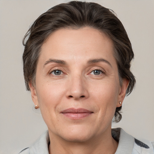 Joyful white adult female with medium  brown hair and grey eyes