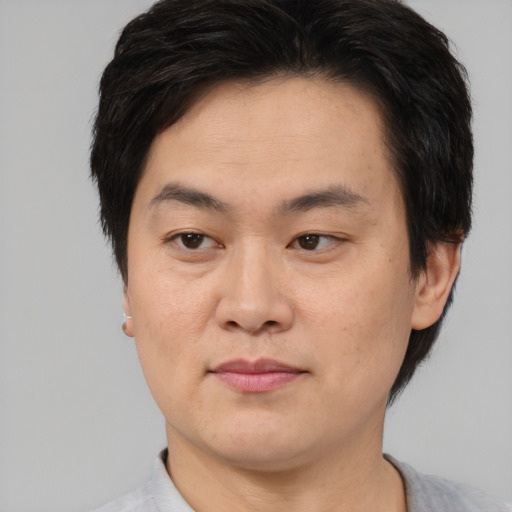 Joyful asian young-adult male with short  brown hair and brown eyes