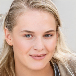 Joyful white young-adult female with long  brown hair and blue eyes