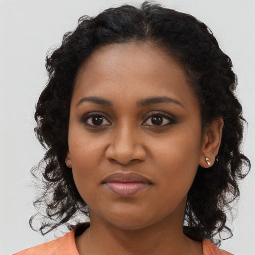 Joyful black young-adult female with long  black hair and brown eyes
