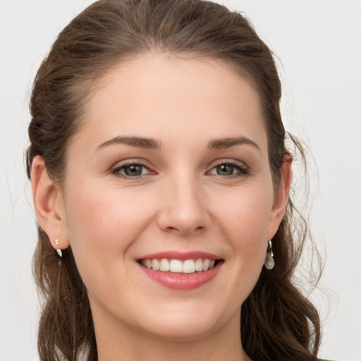 Joyful white young-adult female with long  brown hair and grey eyes