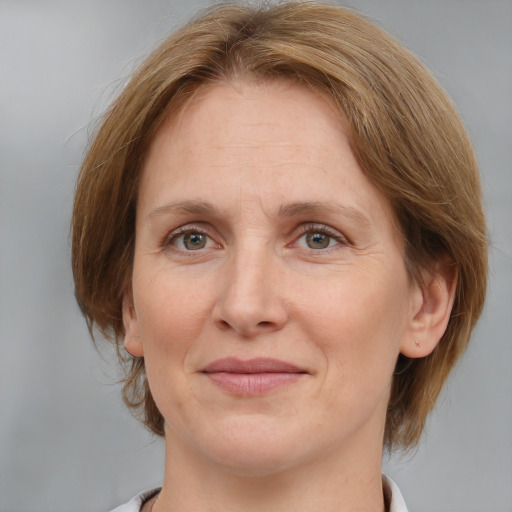 Joyful white adult female with medium  brown hair and grey eyes