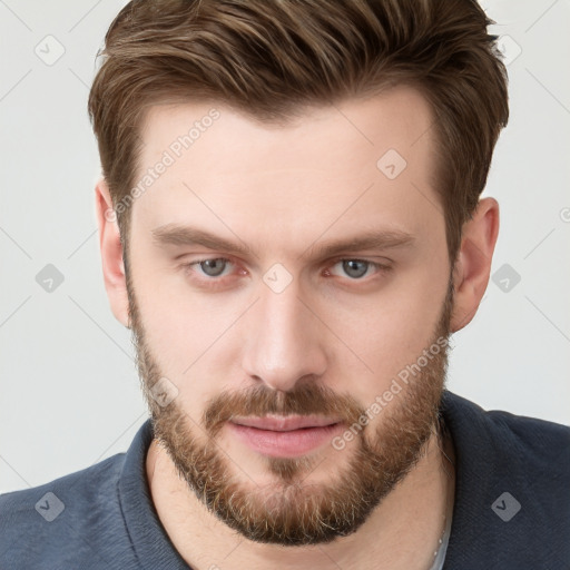 Joyful white young-adult male with short  brown hair and grey eyes