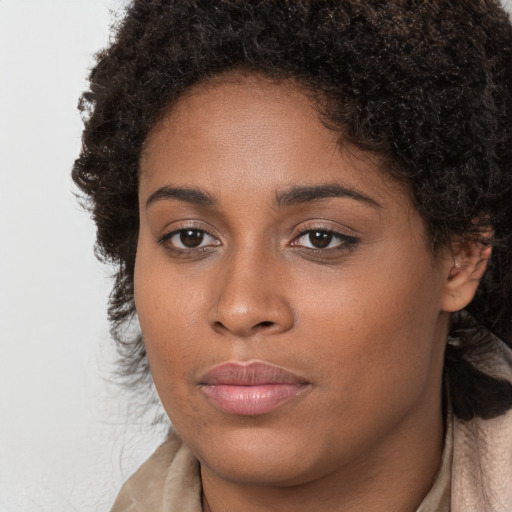 Joyful black young-adult female with long  brown hair and brown eyes