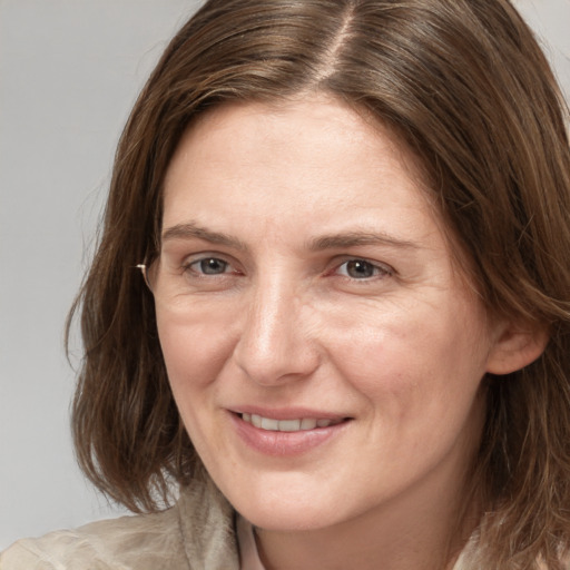 Joyful white adult female with medium  brown hair and brown eyes