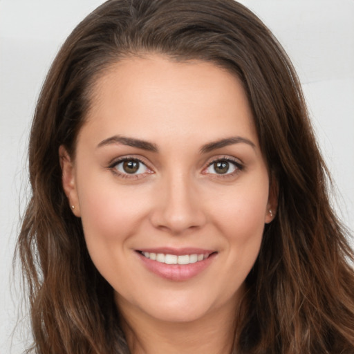 Joyful white young-adult female with long  brown hair and brown eyes