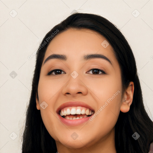 Joyful latino young-adult female with long  black hair and brown eyes