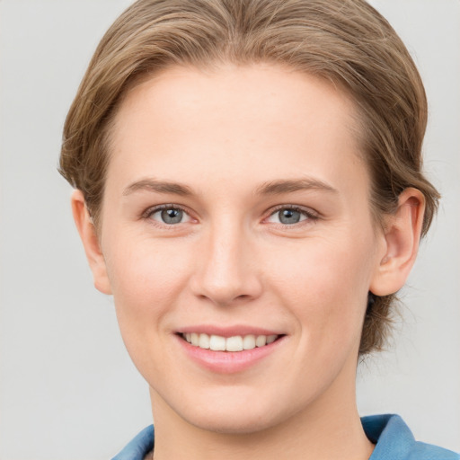 Joyful white young-adult female with short  brown hair and blue eyes