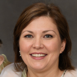 Joyful white adult female with medium  brown hair and blue eyes