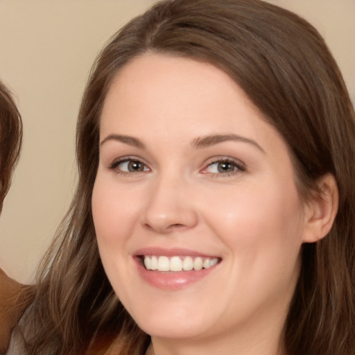 Joyful white young-adult female with long  brown hair and brown eyes