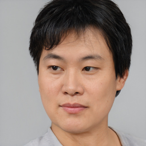 Joyful asian young-adult male with short  brown hair and brown eyes