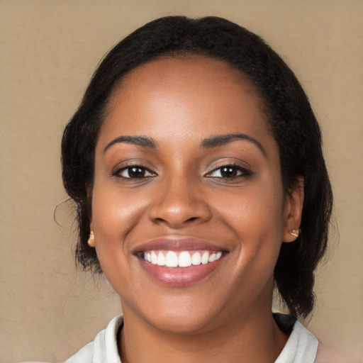 Joyful black young-adult female with long  black hair and brown eyes