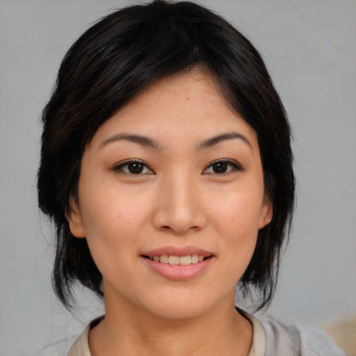 Joyful asian young-adult female with medium  black hair and brown eyes