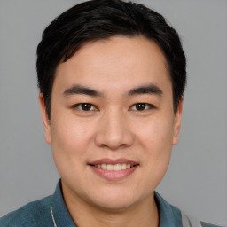 Joyful asian young-adult male with short  brown hair and brown eyes