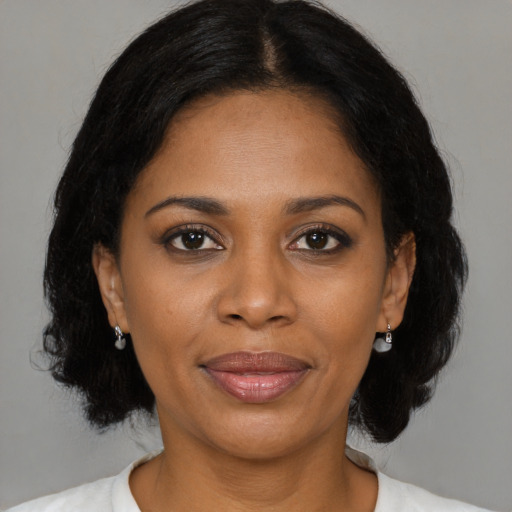 Joyful black adult female with medium  black hair and brown eyes