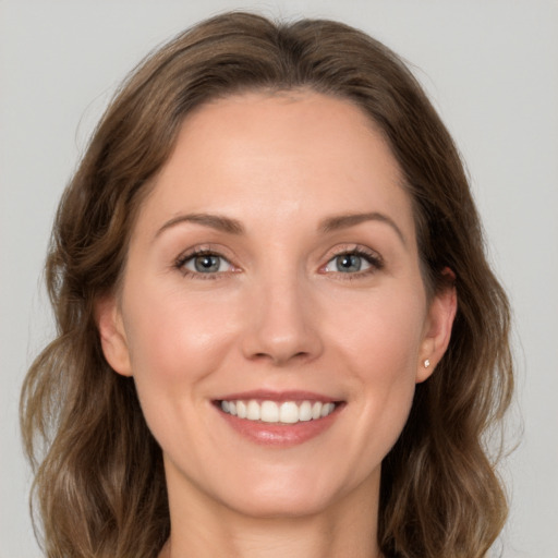 Joyful white young-adult female with medium  brown hair and grey eyes