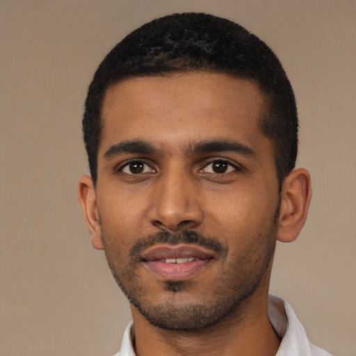 Joyful black young-adult male with short  black hair and brown eyes