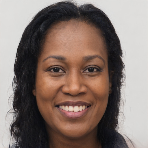 Joyful black adult female with long  brown hair and brown eyes