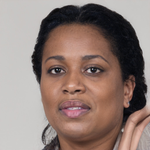 Joyful black adult female with short  black hair and brown eyes