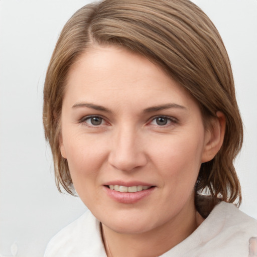 Joyful white young-adult female with medium  brown hair and grey eyes