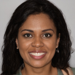 Joyful black young-adult female with long  brown hair and brown eyes