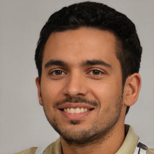Joyful white young-adult male with short  black hair and brown eyes