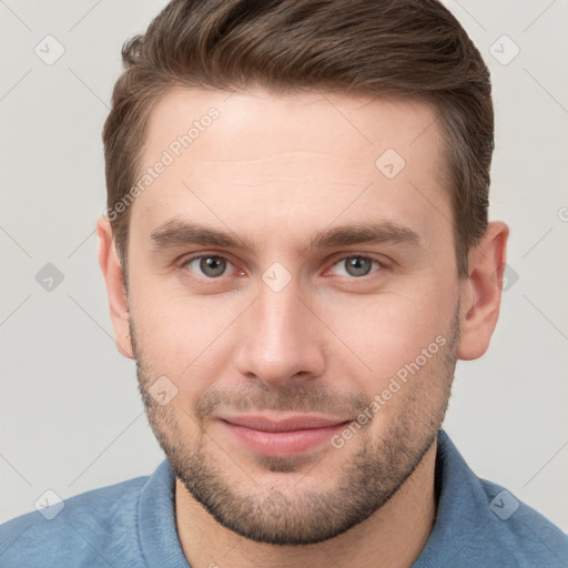 Joyful white young-adult male with short  brown hair and grey eyes