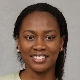 Joyful black young-adult female with long  brown hair and brown eyes