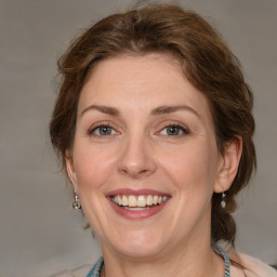 Joyful white adult female with medium  brown hair and blue eyes