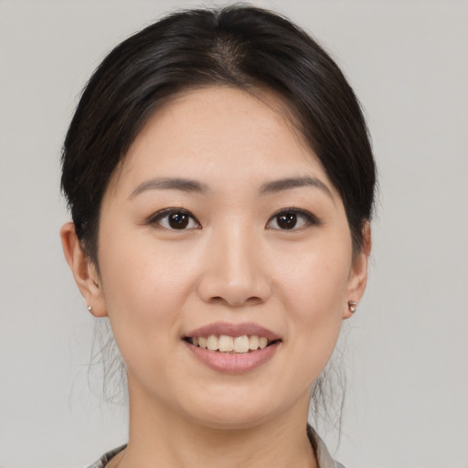Joyful asian young-adult female with medium  brown hair and brown eyes