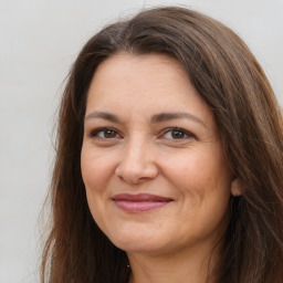 Joyful white adult female with long  brown hair and brown eyes