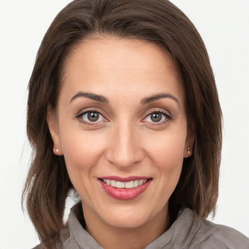 Joyful white young-adult female with medium  brown hair and grey eyes