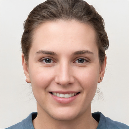 Joyful white young-adult female with medium  brown hair and grey eyes