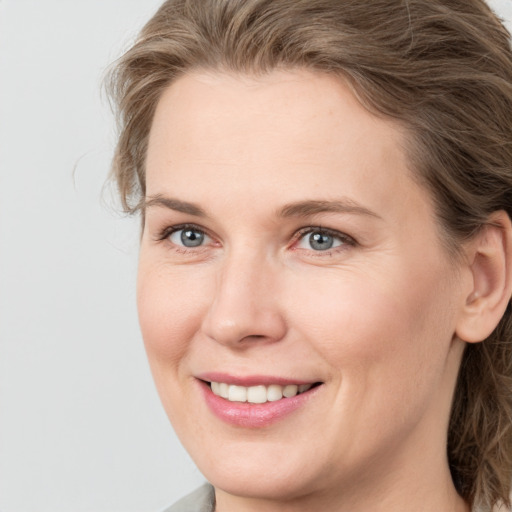 Joyful white young-adult female with medium  brown hair and blue eyes