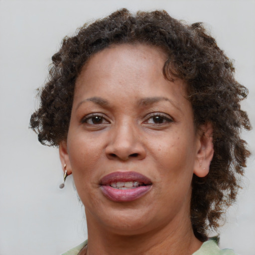 Joyful black adult female with medium  brown hair and brown eyes