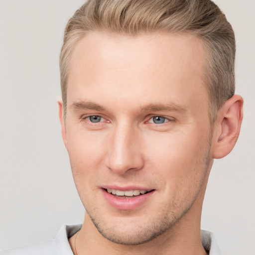 Joyful white young-adult male with short  brown hair and grey eyes