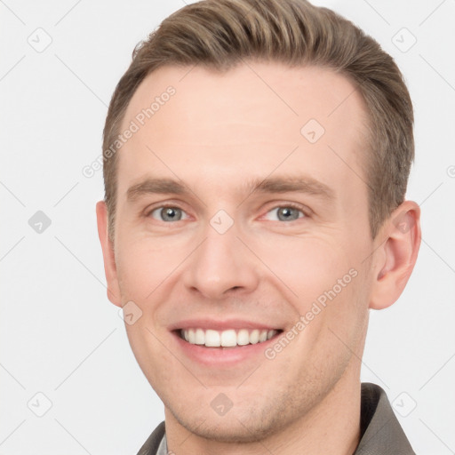 Joyful white young-adult male with short  brown hair and grey eyes