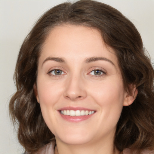 Joyful white young-adult female with medium  brown hair and green eyes