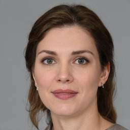 Joyful white young-adult female with medium  brown hair and green eyes