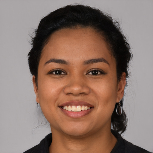 Joyful latino young-adult female with short  black hair and brown eyes