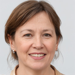 Joyful white adult female with medium  brown hair and grey eyes