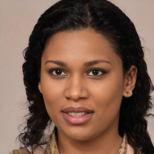 Joyful black young-adult female with long  brown hair and brown eyes