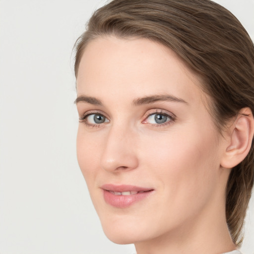 Joyful white young-adult female with medium  brown hair and grey eyes