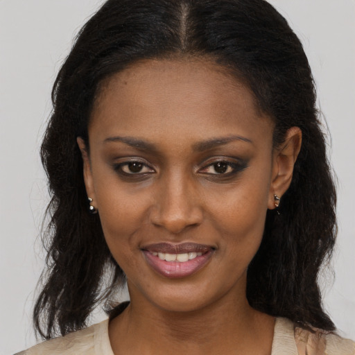 Joyful black young-adult female with long  brown hair and brown eyes