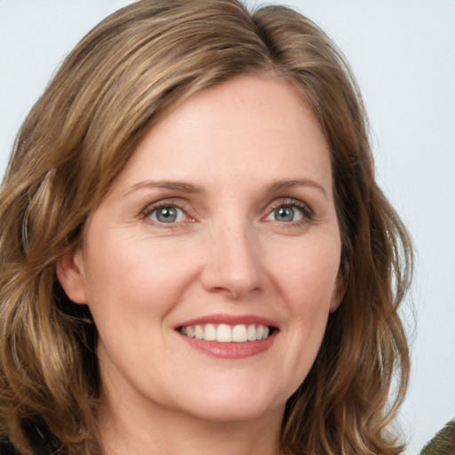 Joyful white young-adult female with medium  brown hair and green eyes