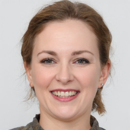 Joyful white young-adult female with medium  brown hair and grey eyes